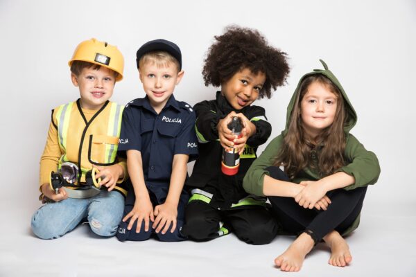 Grupa dzieci w strojach budowniczego, policjanta, strażaka i dinozaura